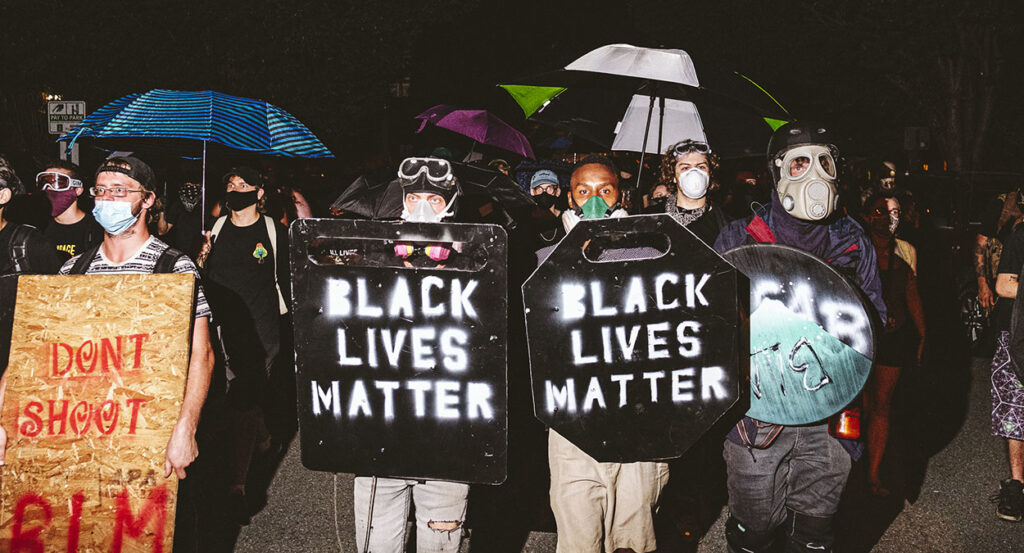 Men in masks with Black Lives Matter shields