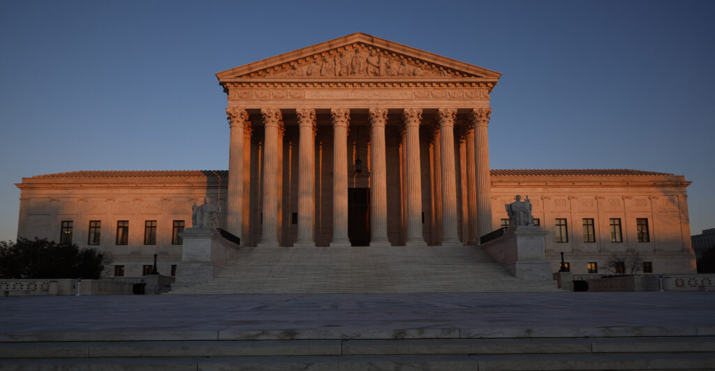 The Supreme Court building with the sun setting