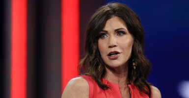 Kristi Noem in a red shirt speaking