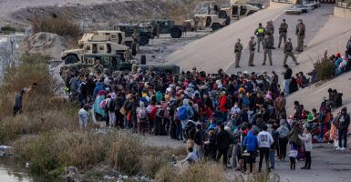 Texas National Guard troops block immigrants from entering a high-traffic border crossing area along Rio Grande in El Paso, Texas