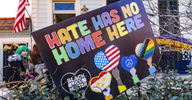 Black sign reads "Hate has no home here" and "Black Lives Matter" in front of a home in New Orleans