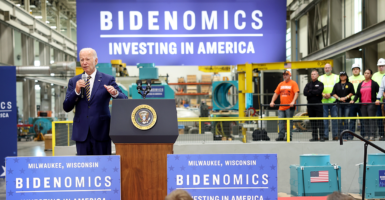 President Joe Biden speaks in front of a sign reading "Bidenomics."
