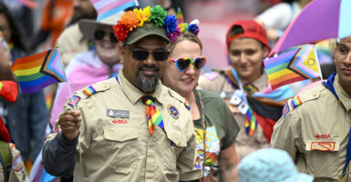 Boy Scouts in uniform march in pride parade