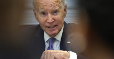 President Joe Biden gestures in a suit with an American flag pin
