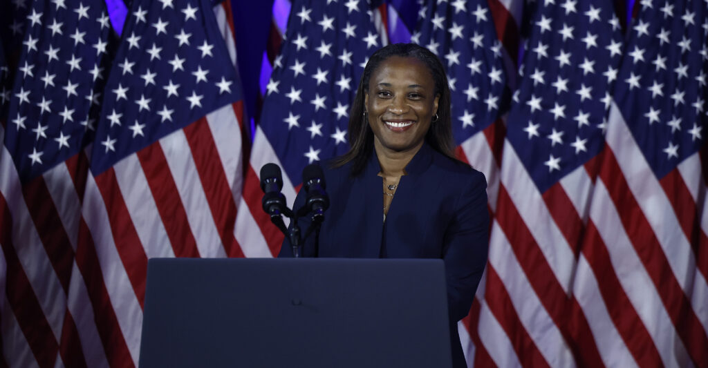 Laphonza Butler in front of American flags