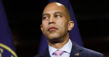 Hakeem Jeffries in a blue suit looks to the left