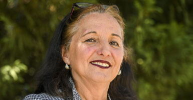 Buta Biberaj smiles while wearing earrings
