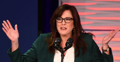 Tiffany Justice, in a black and white suit, gestures with a smile on her face.