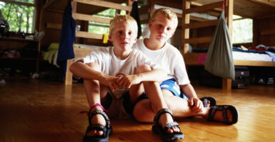 Two young blond boys in a room with bunk beds