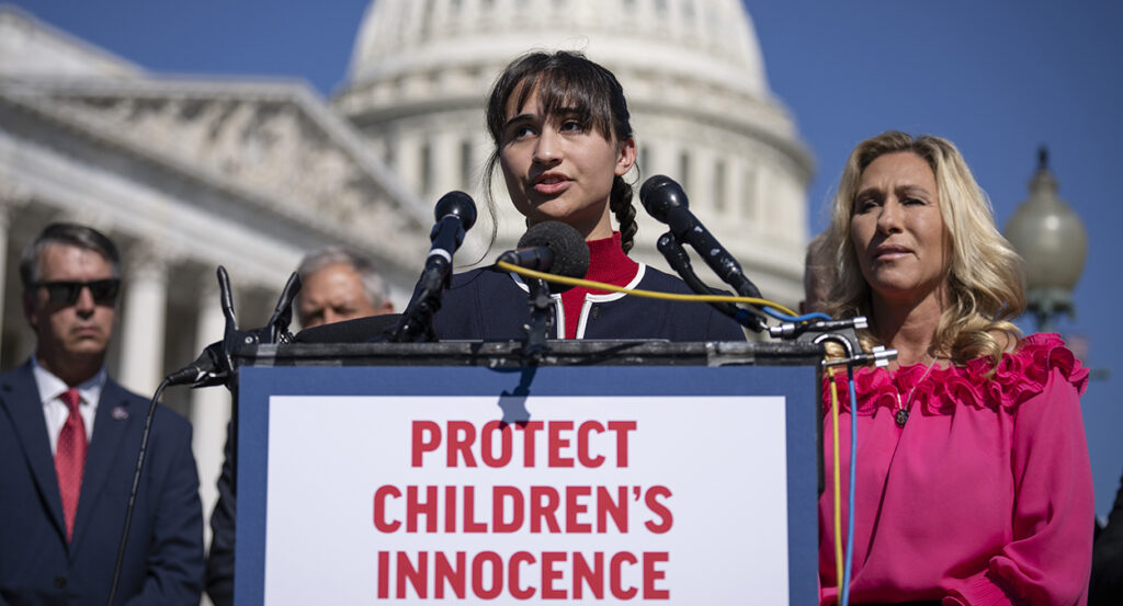 Detransitioner Chloe Cole speaks wearing red and blue at the Capitol building