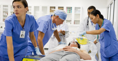 Five doctors and nurses working on a patient in the emergency room