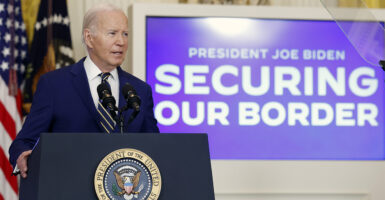 Joe Biden at the White House podium with a screen behind him that says securing our border