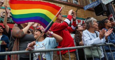 A child waves a rainbow flag at a gay pride parade during the month of June in Los Angeles.