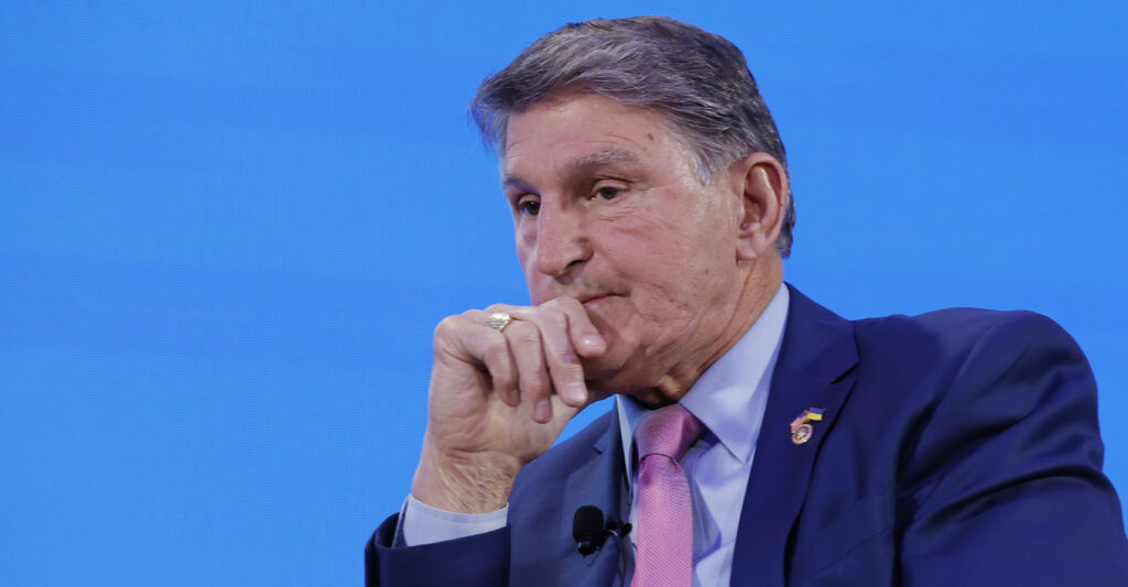 Joe Manchin rests his hand against his chin.