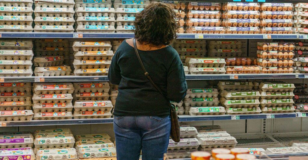 A shopper is seen at Whole Foods Market Staring at a wall full of egg cartons