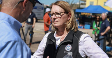 Deanne Criswell scowls in a vest with the FEMA logo
