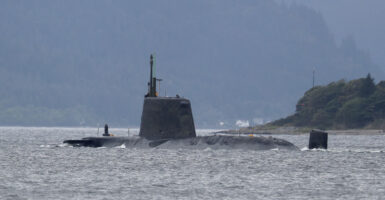 A British navy sub peeking out of the water near shore