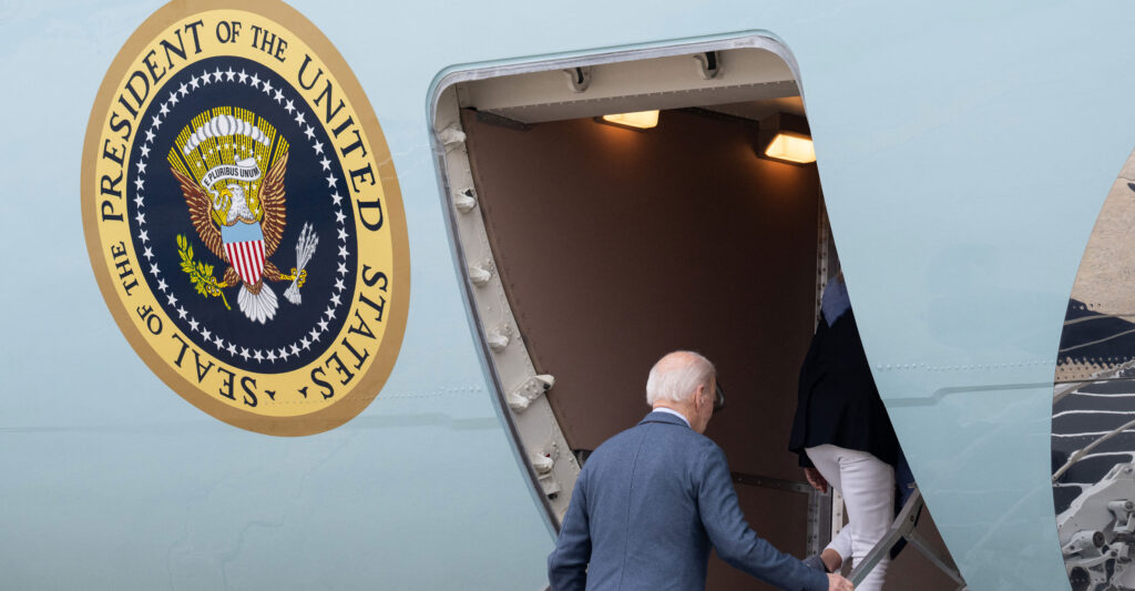 President Joe Biden, seen from behind, boards Air Force One.