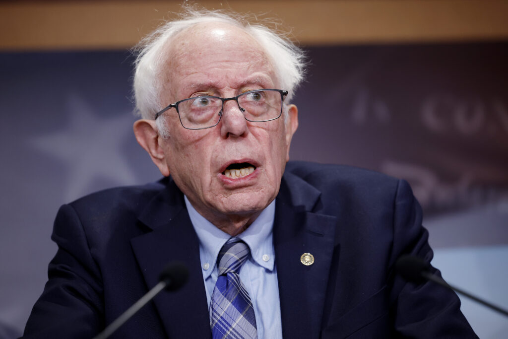 Bernie Sanders at podium in a dark suit and tie