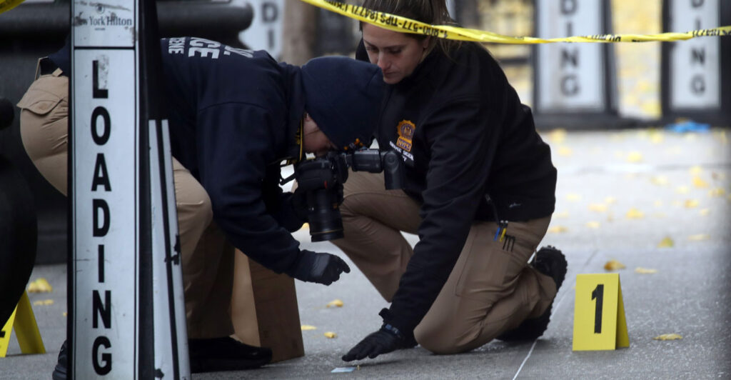 Two police officers work at a crime scene.