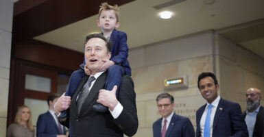 Elon Musk at the Capitol with a young son riding piggyback