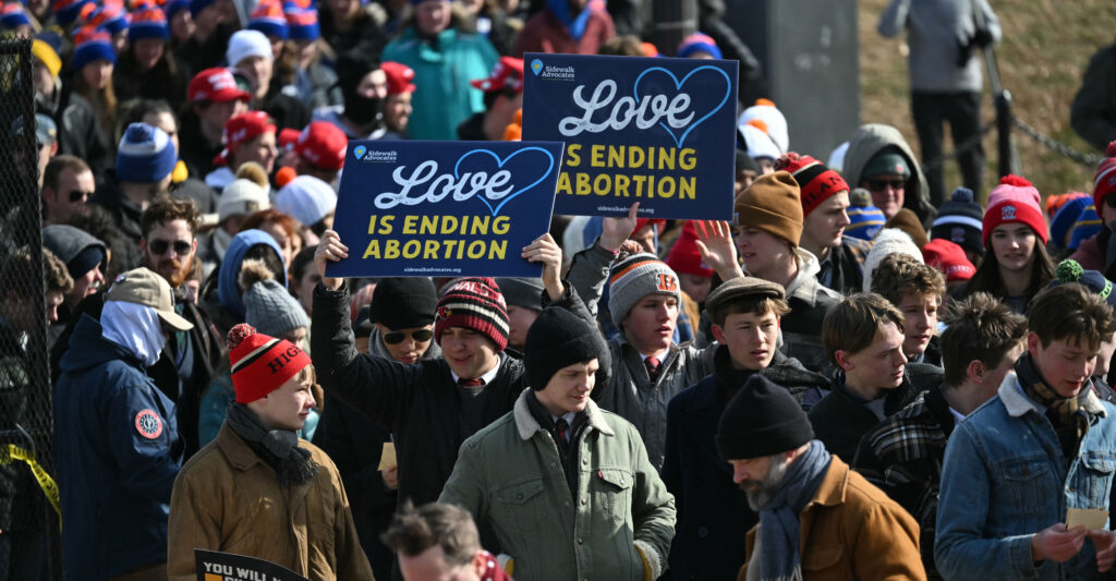 Pro-life activists rally on the National Mall in Washington, D.C., carrying signs reading "Love is ending abortion."