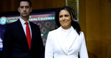 Tulsi Gabbard, nominated to be director of national intelligence, arrives Thursday for her Senate Intelligence Committee confirmation hearing as the panel's chairman, Sen. Tom Cotton, R-Ark., looks on.