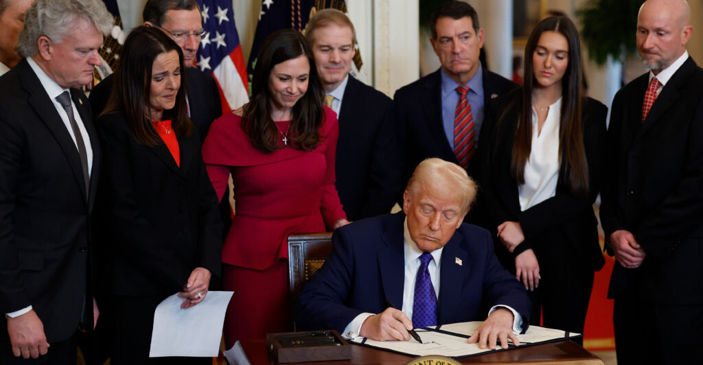Surrounded by members of Congress and the family of Laken Riley, President Donald Trump signs the Laken Riley Act into law at the White House on Wednesday.