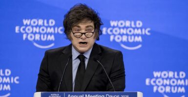 Argentina's President Javier Milei looks forward as he speaks at a podium.