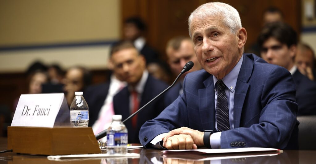 Anthony Fauci sits at a table with a microphone in front of him as he testifies.