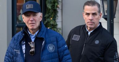 Joe Biden and Hunter Biden stand outdoors next to each other while wearing winter jackets.