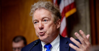 Sen. Rand Paul gestures in a blue suit