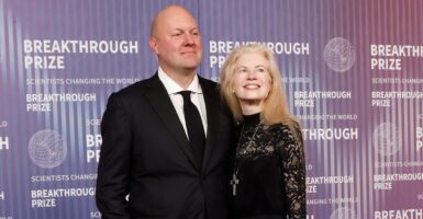 Marc Andreessen stands next to his wife with his hands by his side at an awards ceremony.
