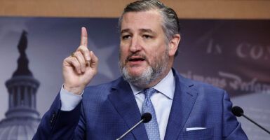 Sen. Ted Cruz raises his finger in a blue suit
