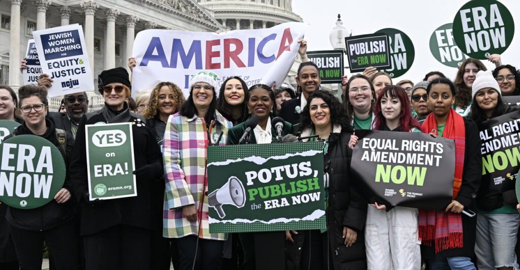 Several female protesters outside the U.S. Capitol holding up signs urging adding the equal rights amendment to the Constitution of the United States