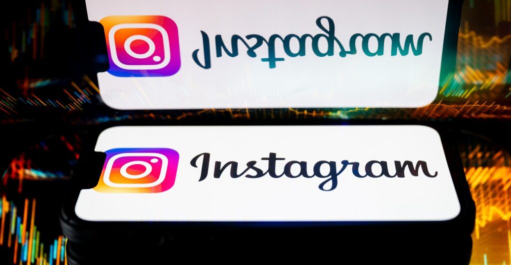 A Smartphone lays on a counter next to a mirror and there is a reflection of it.