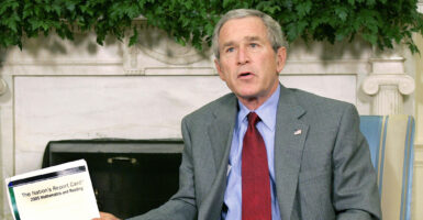 Then-President George W. Bush holds a copy of the Nation's Report Card on Oct. 19, 2005.