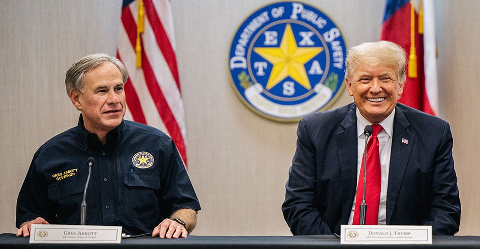 Texas Govenor Greg Abbott and President Donald Trump sit side-by-side at a table.