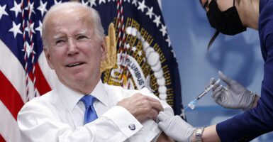 Joe Biden grimaces as he gets a shot of the COVID-19 vaccine.