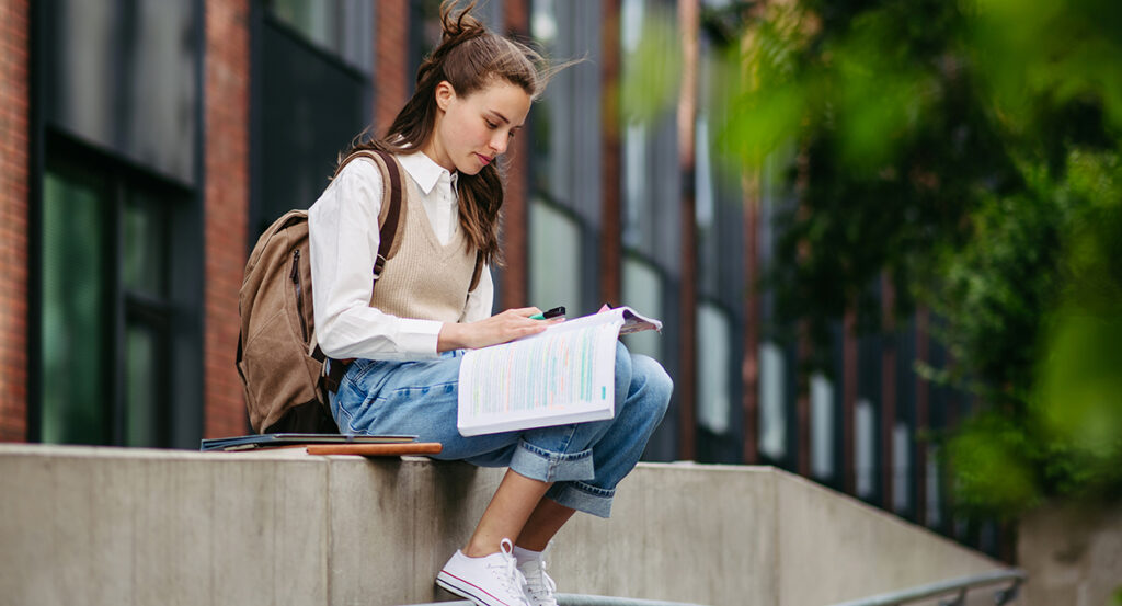 A female college student studying outdoors on campus
