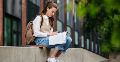 A female college student studying outdoors on campus