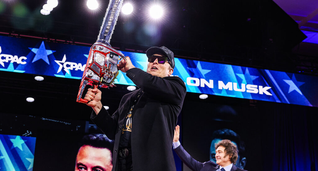 Elon Musk holds a chainsaw at CPAC
