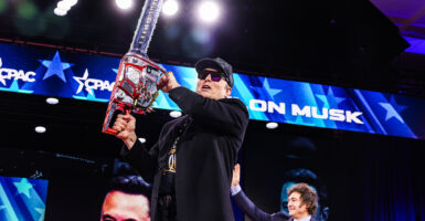 Elon Musk holds a chainsaw at CPAC