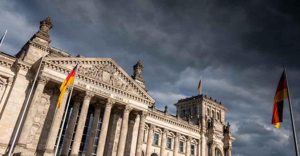Germany's Parliament building with dark clouds in the background.