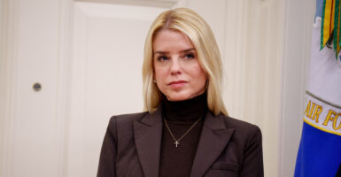 Pam Bondi wears a black turtleneck and silver cross.