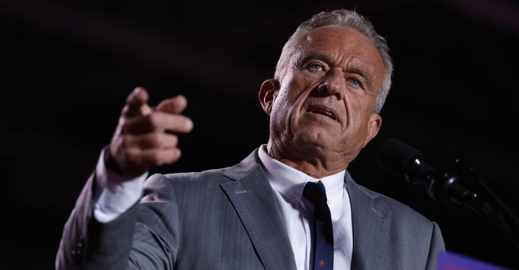 Robert F. Kennedy Jr., stands as he talks and points his right hand.