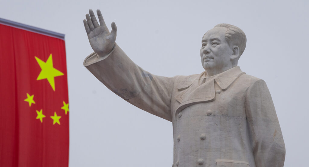 A statue of Mao Zedong and a Chinese flag