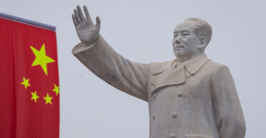 A statue of Mao Zedong and a Chinese flag