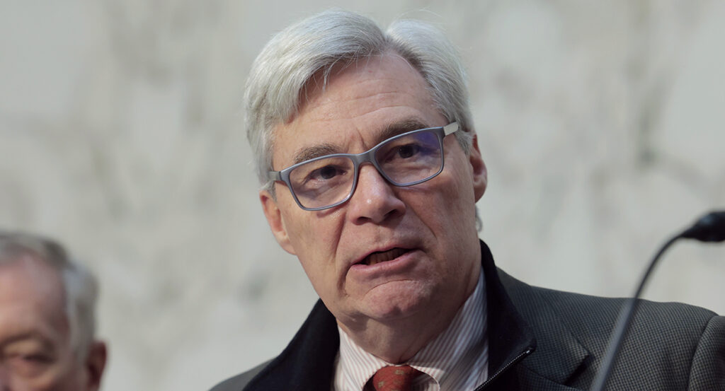 Sheldon Whitehouse in a suit and glasses