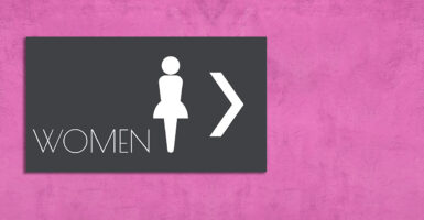A restroom door with an outline logo of a woman
